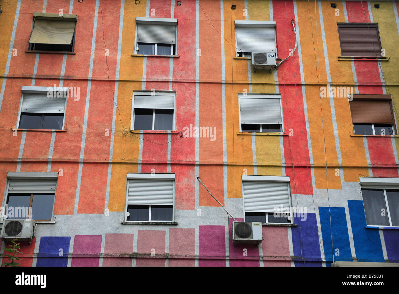 Albanien, Tirana, Tirana, äußere des bunten Wohnung block mit Windows Blinds und Klimaanlage Einheiten. Stockfoto