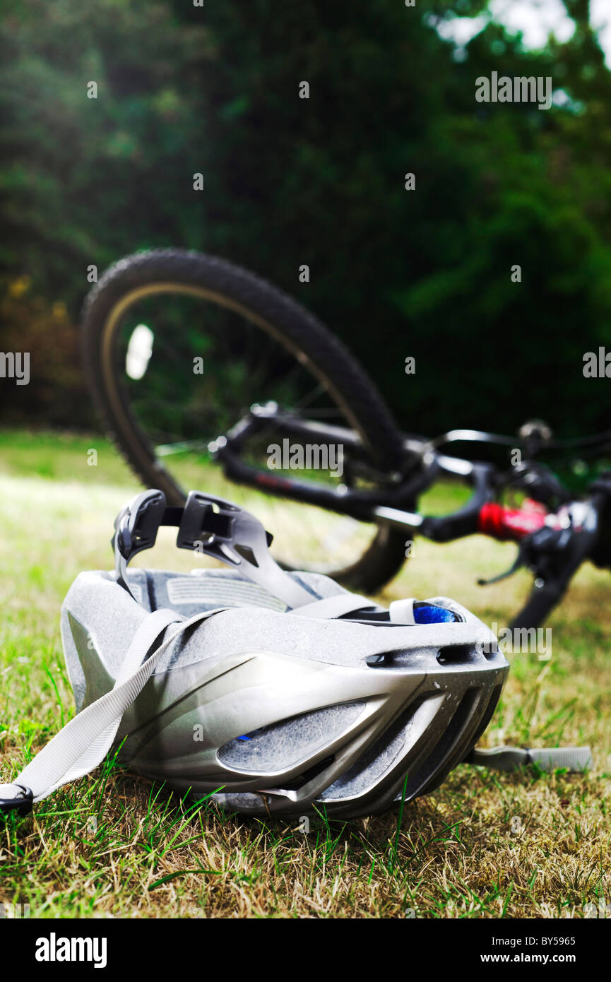 Verlegung auf Rasen mit Mountain-Bike im Hintergrund verschwommen Fahrradhelm Stockfoto