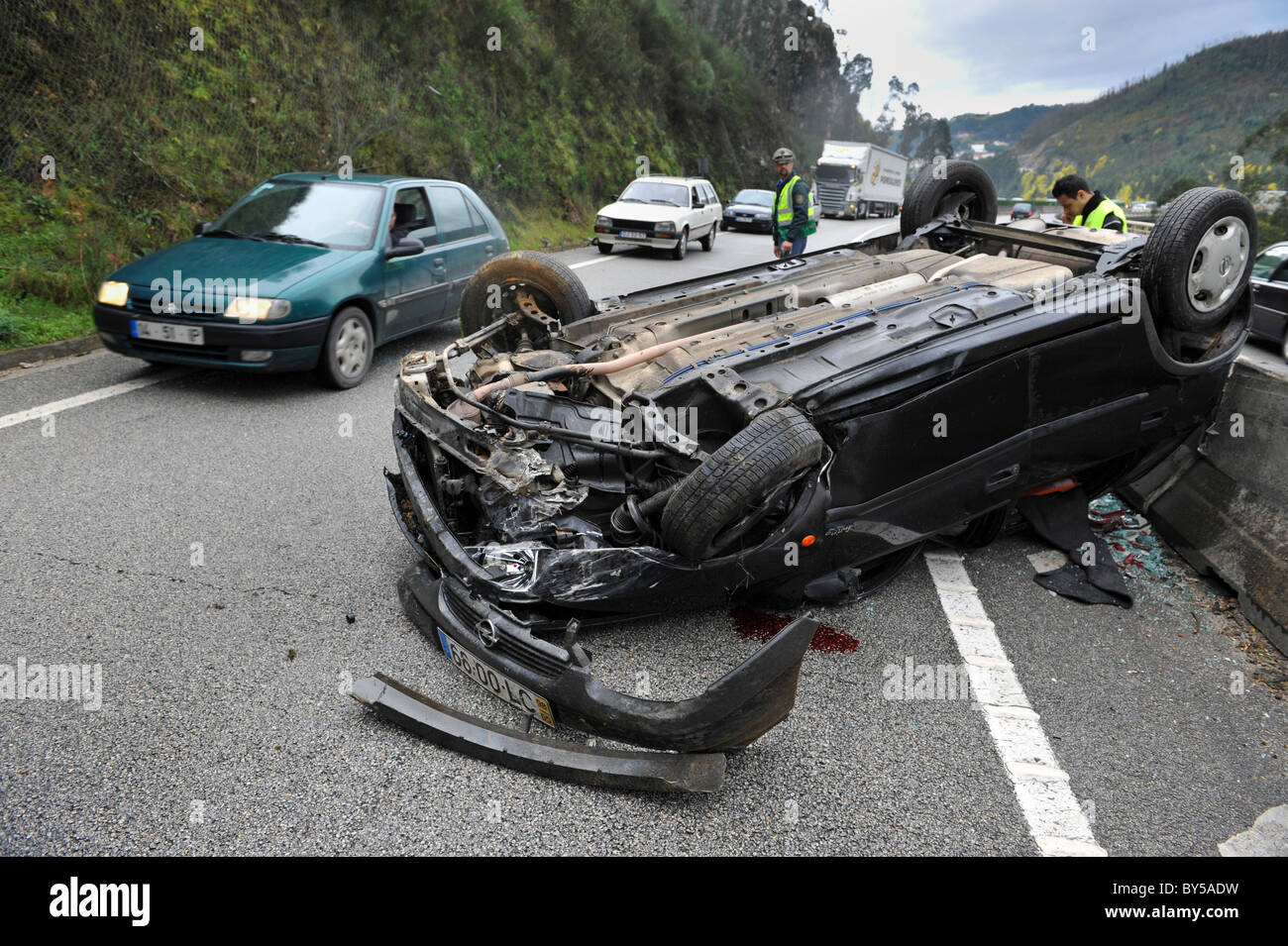 Auto geht nach einem Autounfall von einem zerstörten und umgestürzten Auto IP3 unterwegs in Zentral-Portugal Stockfoto