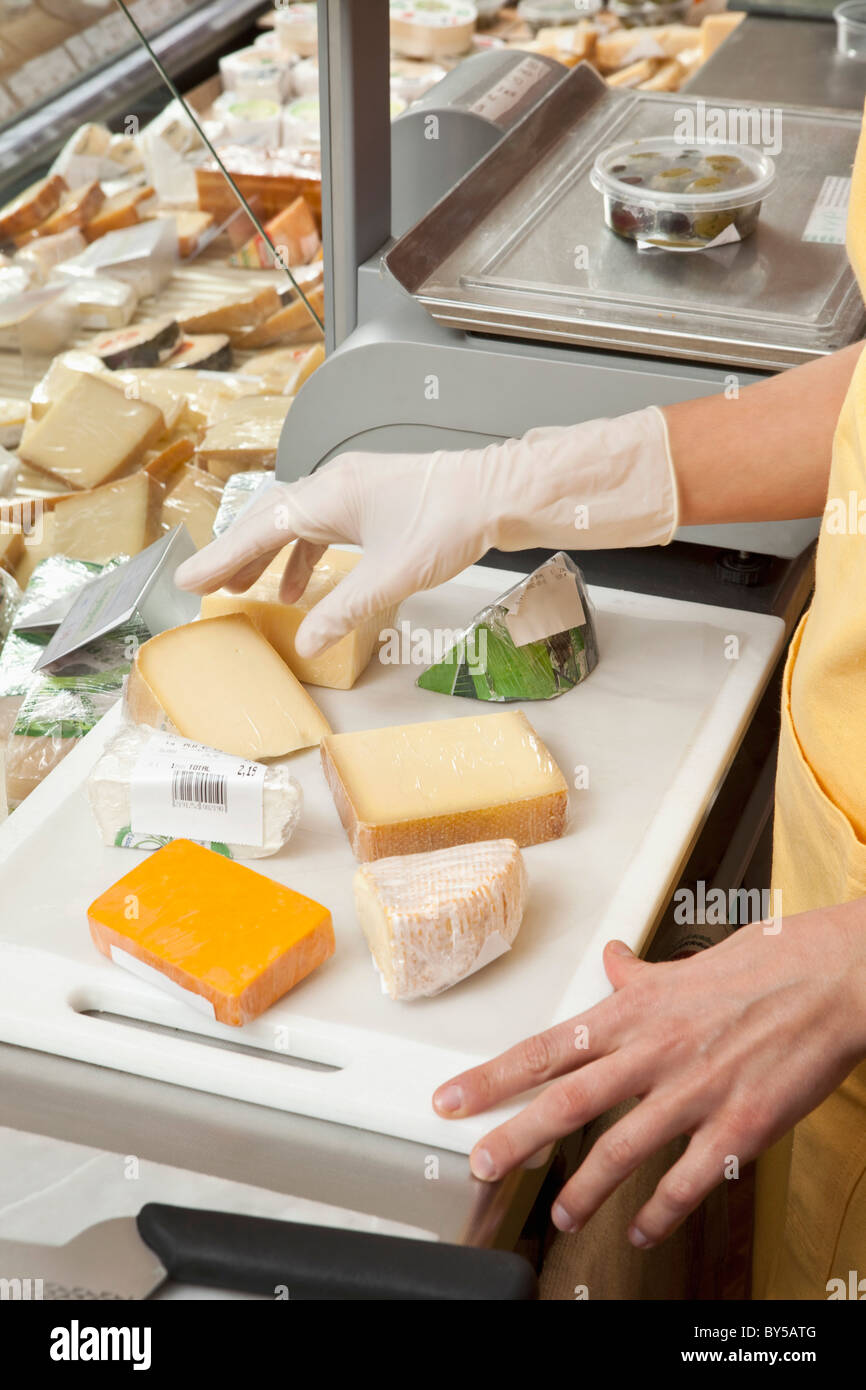 Eine Verkäuferin Vorbereitung Keile Käse Stockfoto