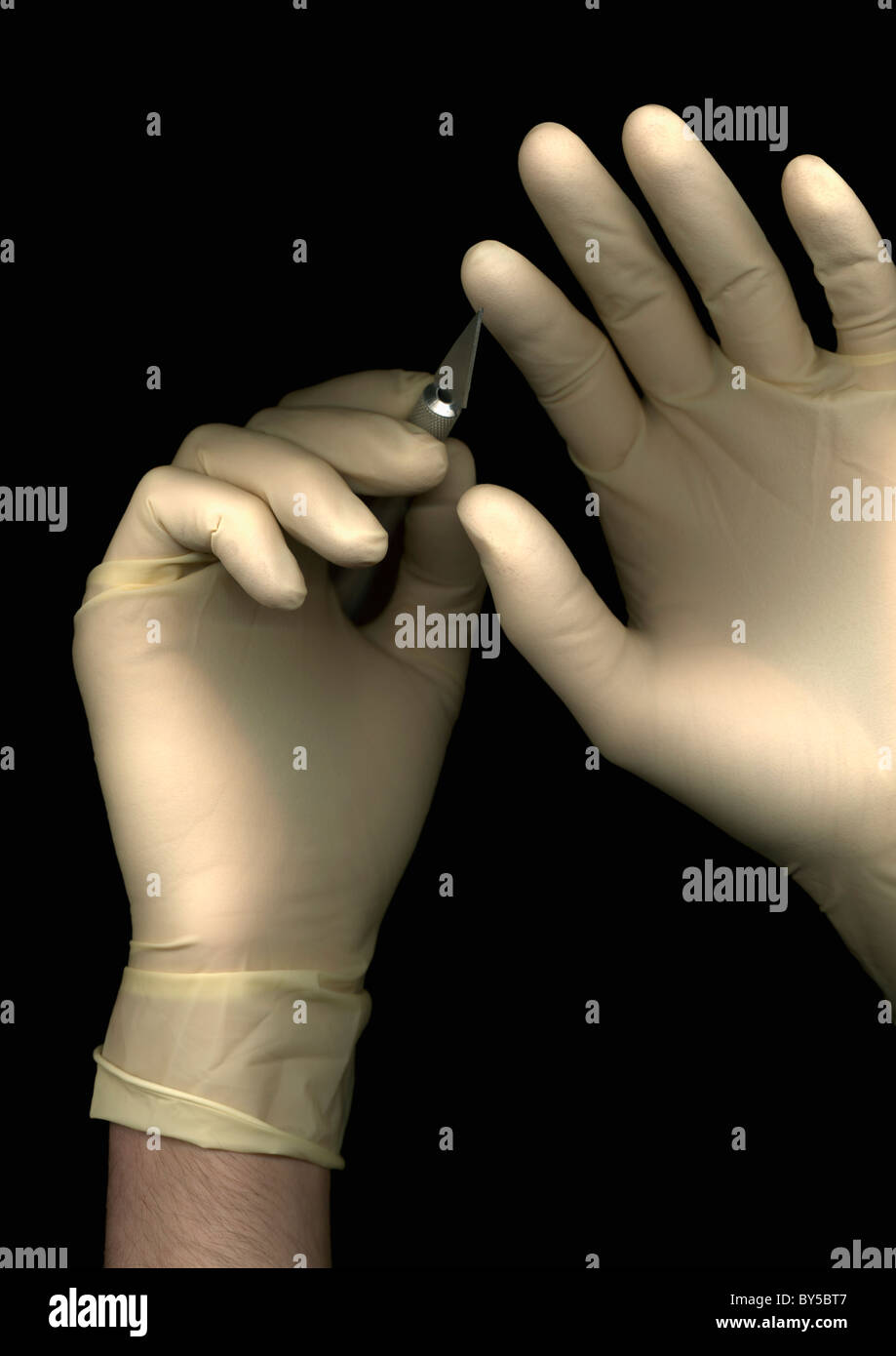 Ein Mann trägt einen OP-Handschuhe und hält ein Skalpell Hände direkt unten, nur Stockfoto
