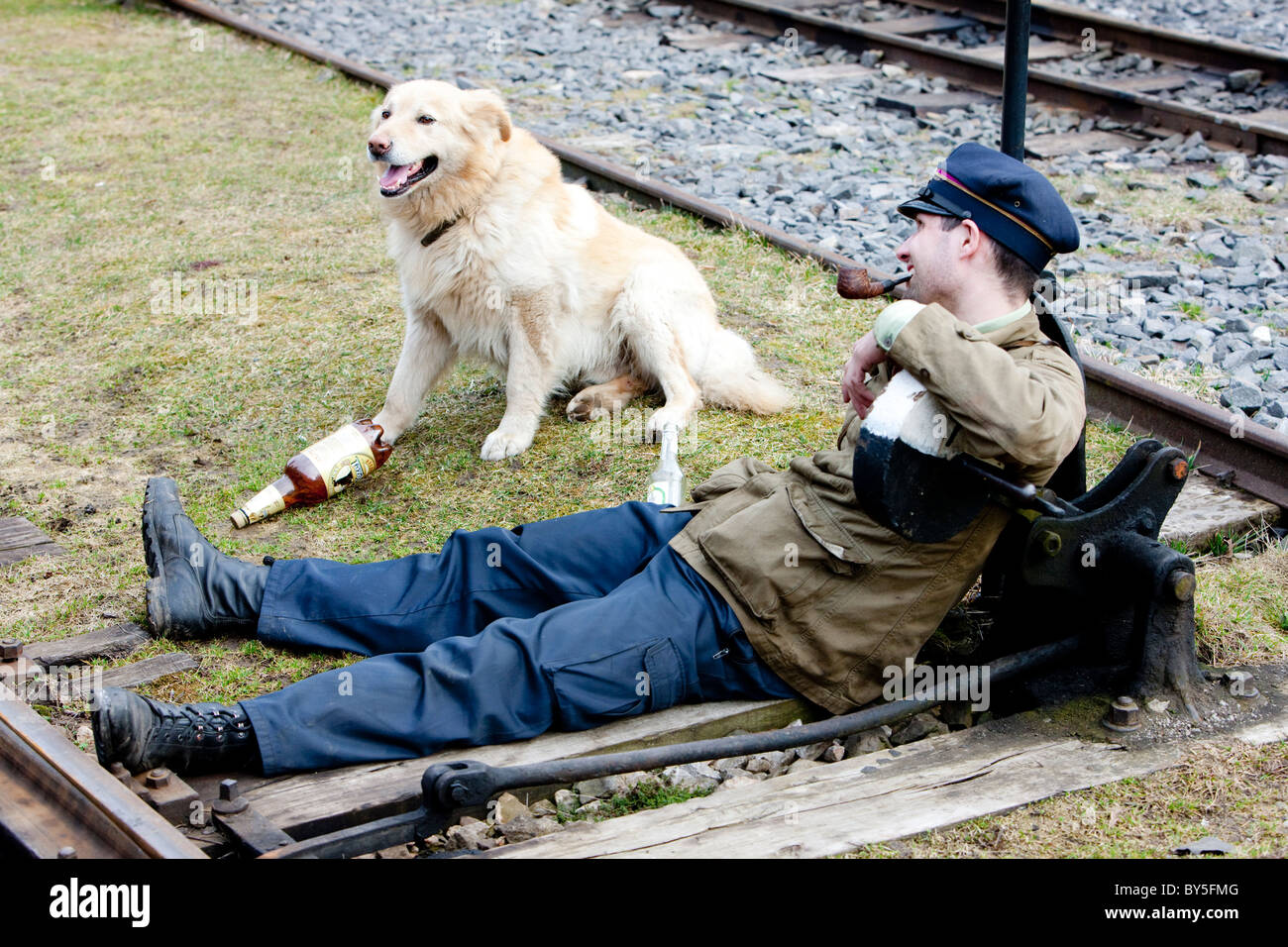 Mann, sitzend mit einem Hund am Schalter, Ciernohronska Eisenbahn, Slowakei Stockfoto