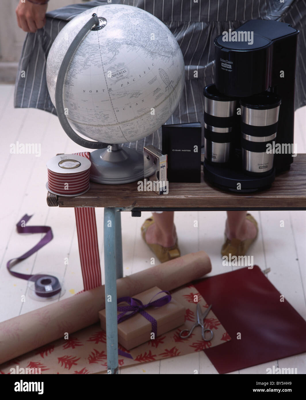 Nahaufnahme von Atlas Globus und Kaffeemaschine in Tabelle oben Rollen Geschenkpapier auf dem Boden Stockfoto