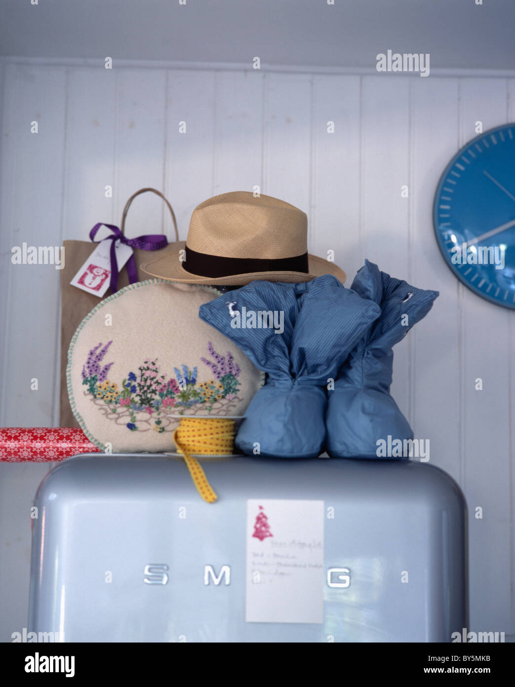 Nahaufnahme von bestickt vierziger Jahren Tee-gemütlich mit Strohhut und blaue Pantoffel-Stiefel auf Smeg Kühlschrank im Retro-Küche Stockfoto