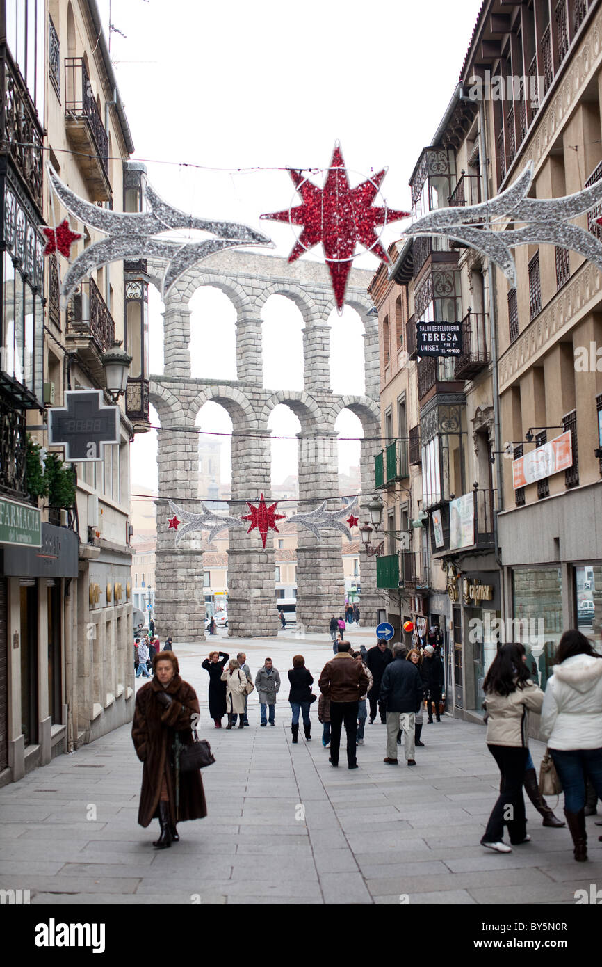 Passanten auf der Straße während des Winters in Segovia, Spanien. Roman Aqueduct von Segovia im Hintergrund. Stockfoto