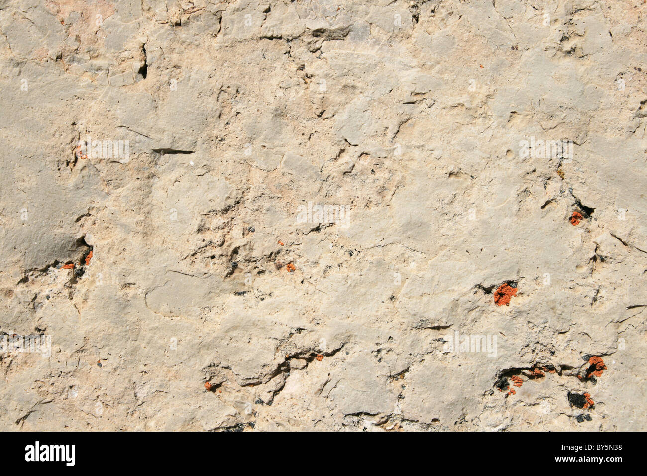 weißen Dolomit Fels Hintergrund mit orangefarbenen Flechten Flecken geknackt Stockfoto