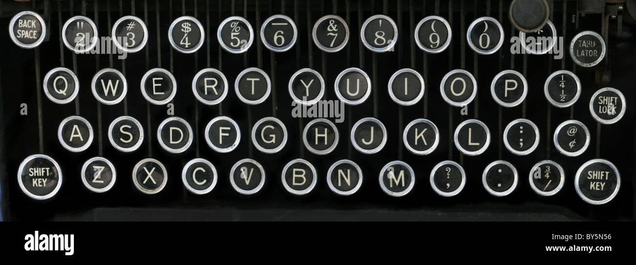 alte Schreibmaschinentastatur mit silbernen und schwarzen runden Tasten mit einem schwarzen Hintergrund Stockfoto