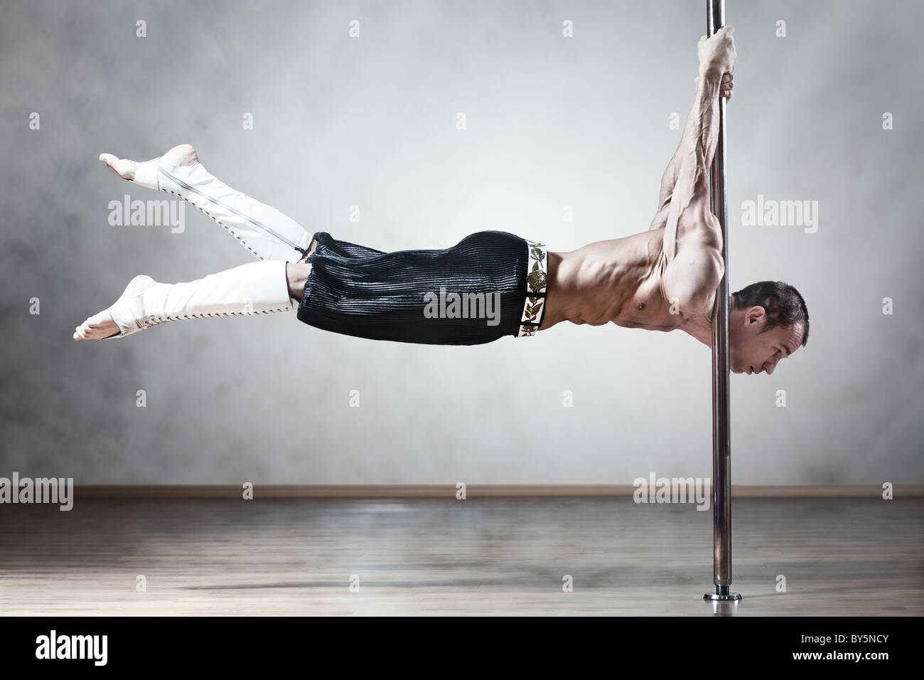 Junge starke Pole-Dance-Mann. Stockfoto