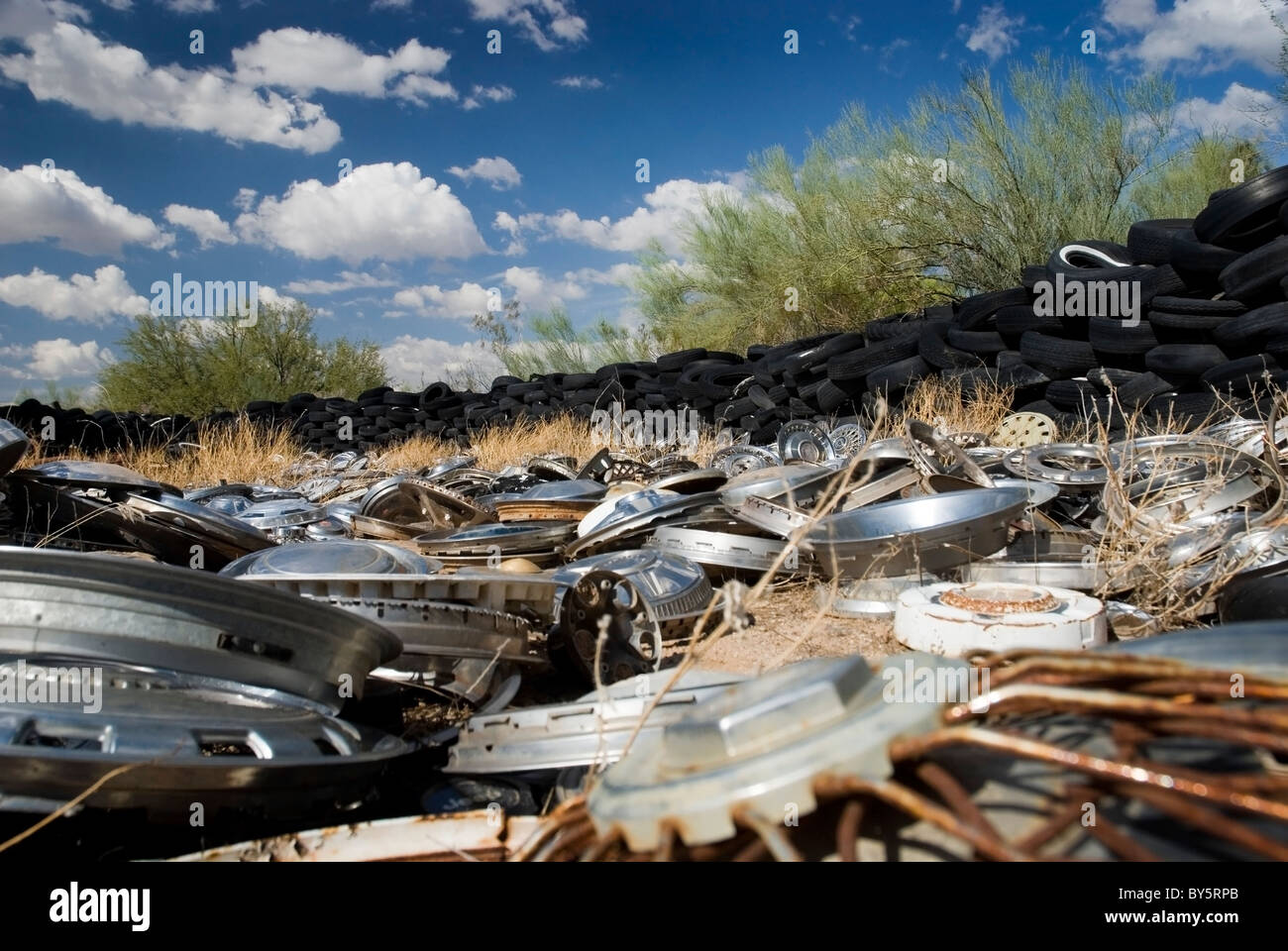 Hub caps, Räder und Reifen verstreut über einen ländlichen Arizona Schrottplatz. Stockfoto