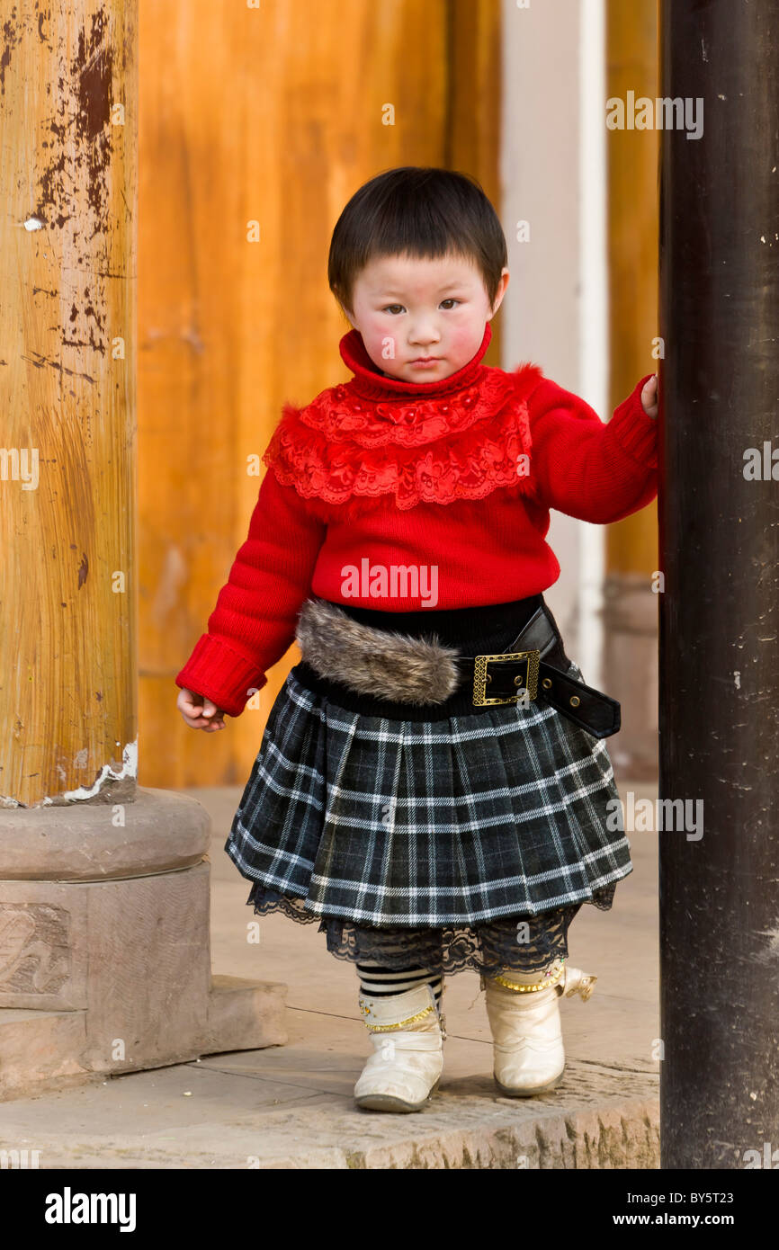 Schöne junge Chinesin tragen Tartan Rock und roten Pullover im Huanglongxi, in der Nähe von Chengdu, Provinz Sichuan, China. JMH4363 Stockfoto