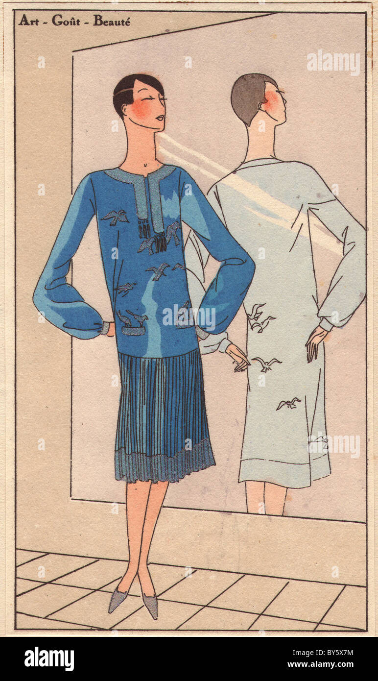 1920er Jahren Frau in blauen Crêpe-Kleid bestickt mit silbernen Vögel, Faltenrock, Stading vor einem Spiegel. Stockfoto