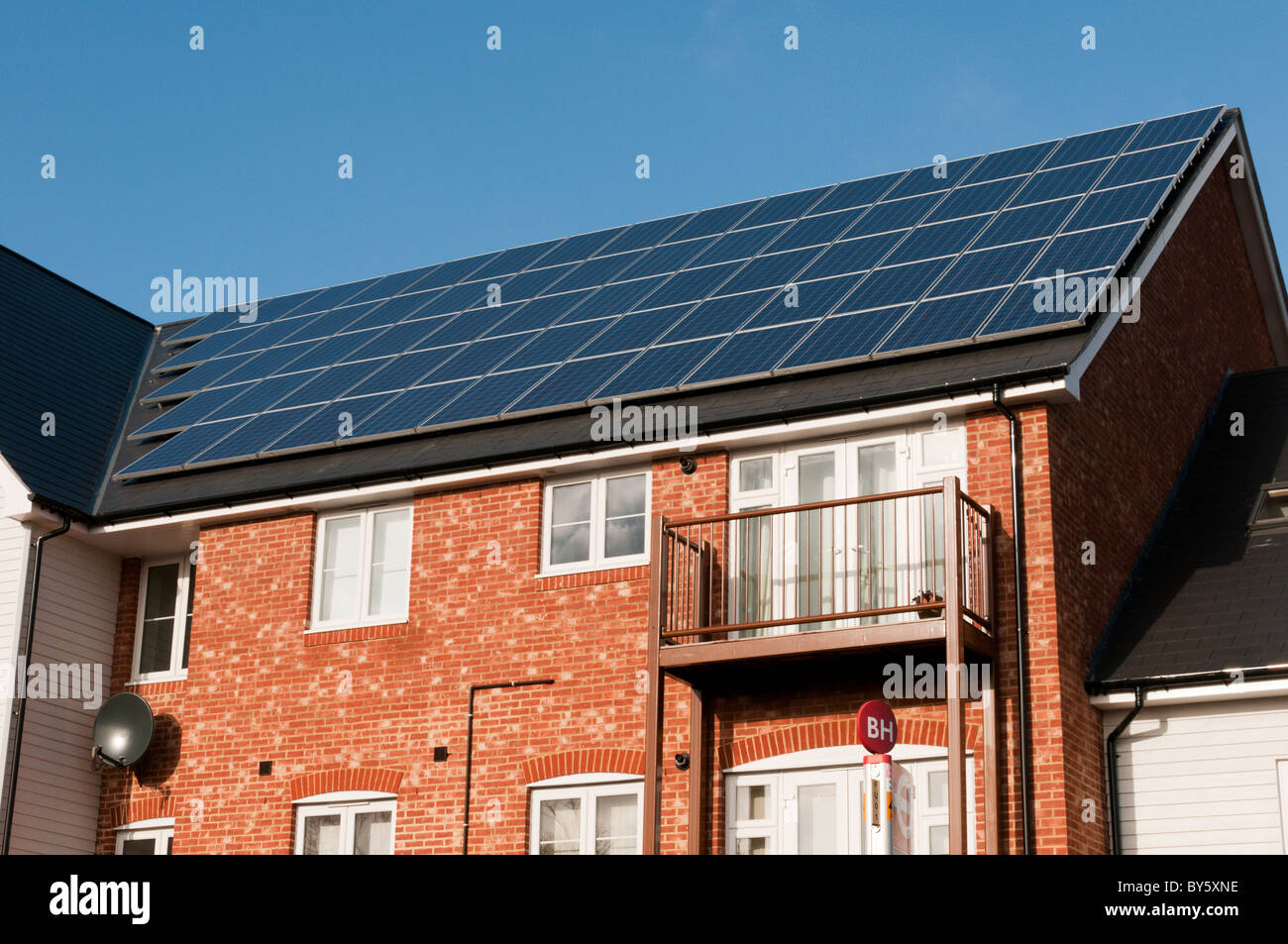 Eine Versorgung mit erneuerbaren Energien in Form von Photovoltaik-Modulen auf dem Dach einer Neuentwicklung in Bromley, Kent, England Stockfoto