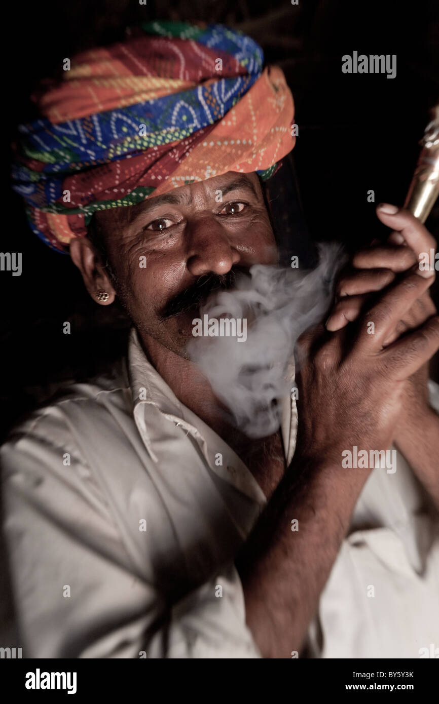 Inder (Mitglied der Sekte Bishnoi) raucht eine Pfeife, nr Jodhpur, Rajasthan, Indien Stockfoto
