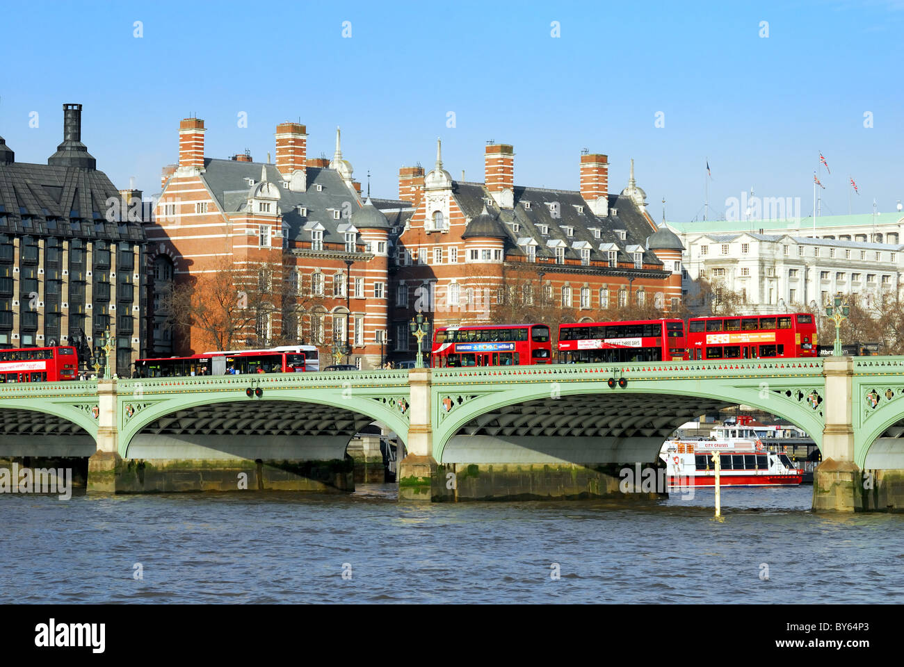 Roten Londoner Busse auf Westminster Bridge mit Themse im Vordergrund Stockfoto