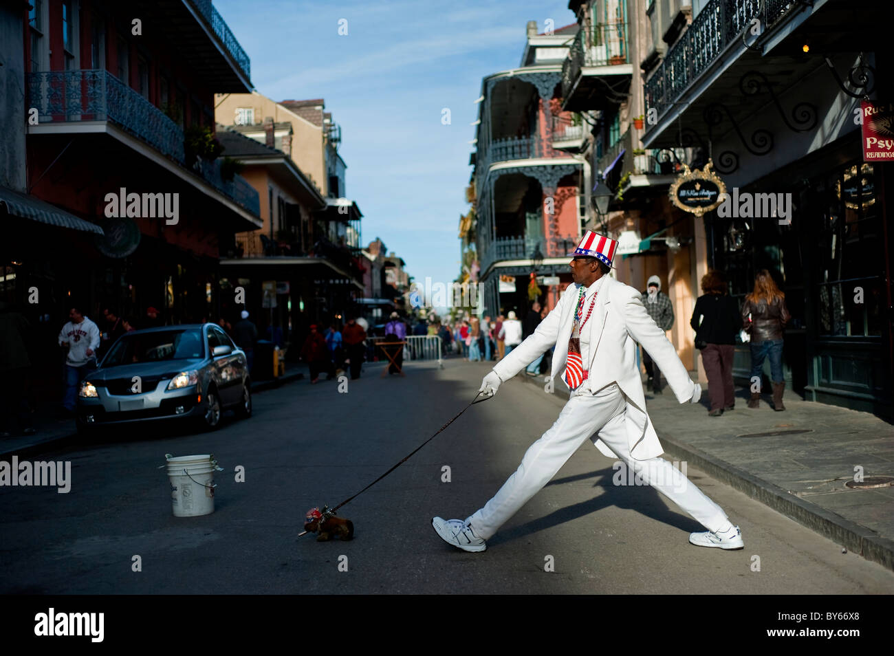 Ein Mann tut, auf der anderen Straßenseite hinter einem ausgestopften Hund auf einer Straße in New Orleans, Louisiana. Stockfoto