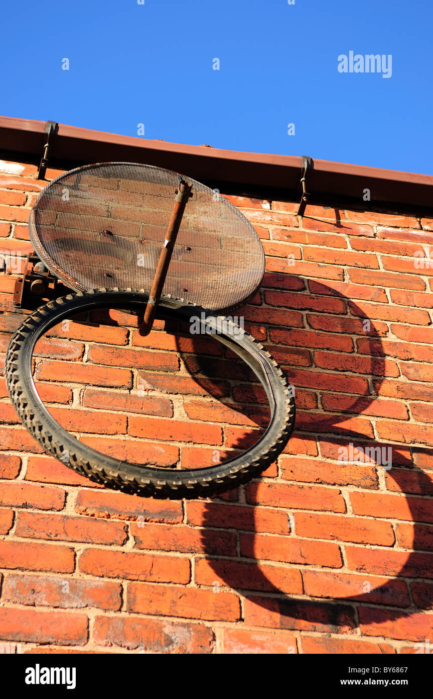 Alten Kautschuk-Zyklus Reifen verzogen um eine Satellitenschüssel. Stockfoto