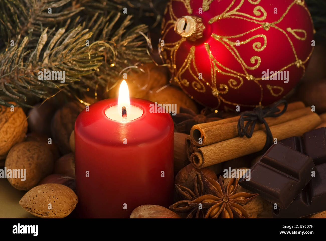 Weihnachts-Dekoration mit Kerzen, Nüssen und Tand als Nahaufnahme Stockfoto