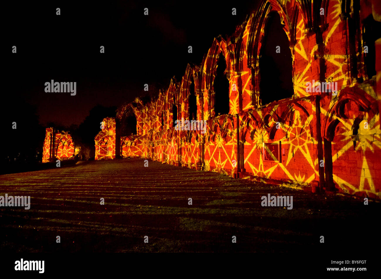 St Mary's Abbey bei Nacht, beleuchtet mit einem orangefarbenen und gelben geometrischen Muster. York. Stockfoto