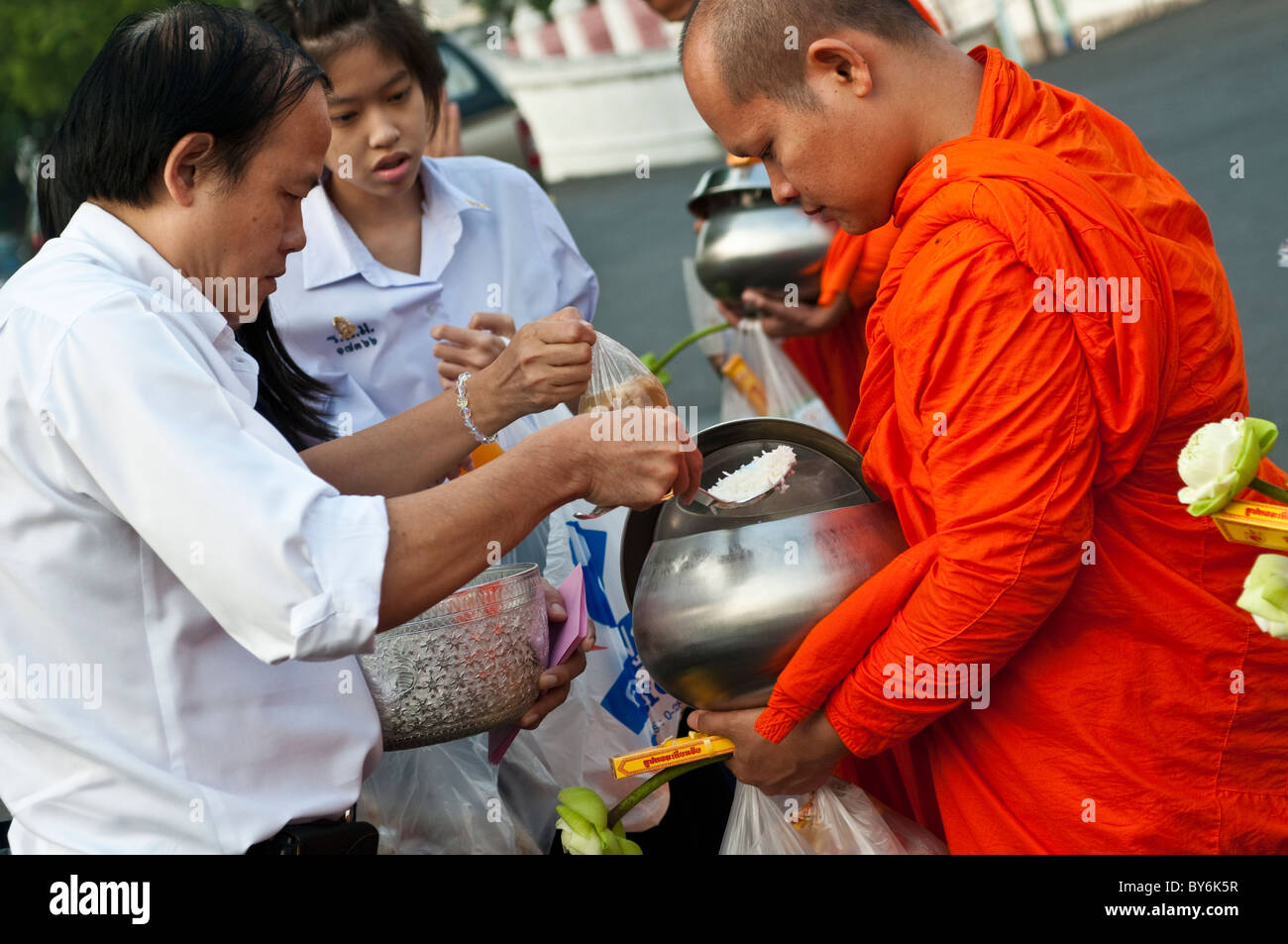 Monk erhält Reis in seine Schale von Verdienst-Machern, Wat Benjamabophit, Bangkok, Thailand Stockfoto