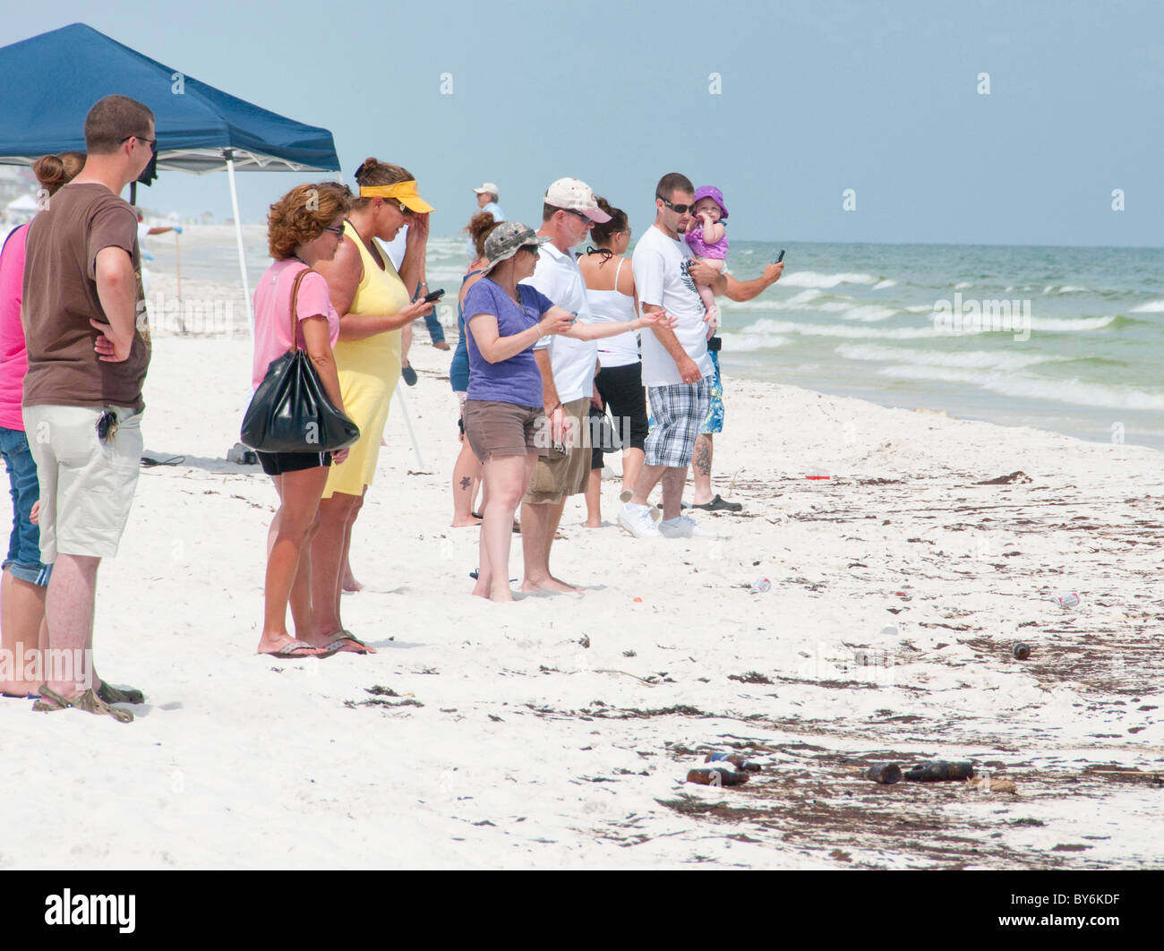 Strandbesucher beobachten, wie Öl an Land in Pensacola wäscht Stockfoto