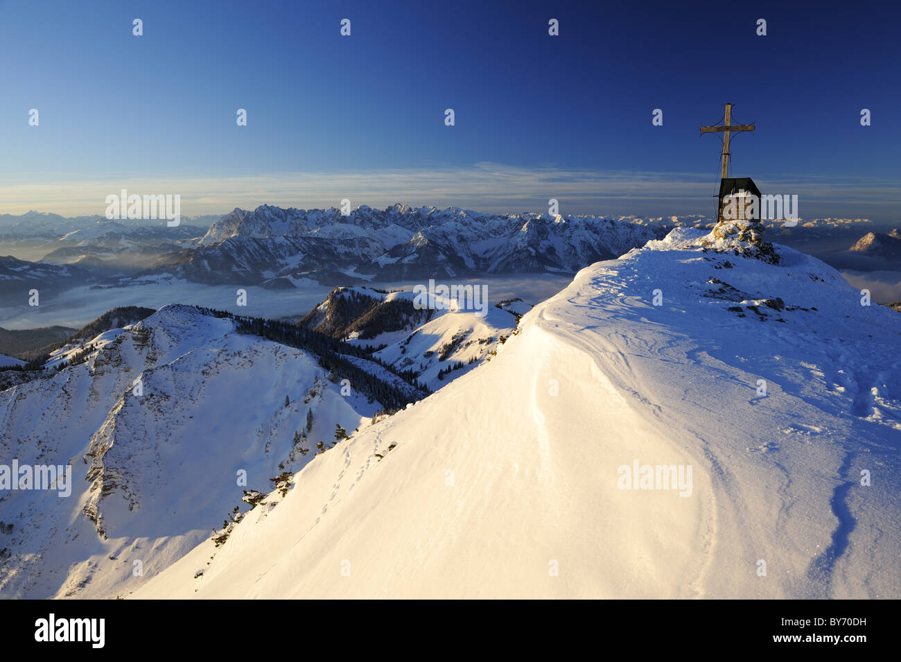 Kreuz und Kapelle auf dem Gipfel der Geigelstein, Kaisergebirge Bergkette im Hintergrund, Geigelstein, Chiemgau Mountainbike ra Stockfoto
