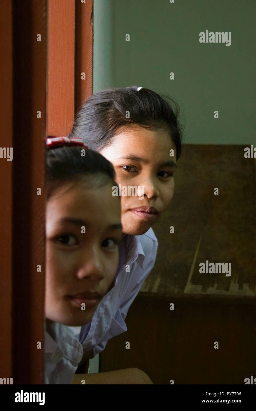 Zwei junge Gehörlose Studentinnen sind auf einem Fensterbrett ihre Klassenzimmer in ein Reha-Zentrum in kommunistische Laos gelehnt. Stockfoto