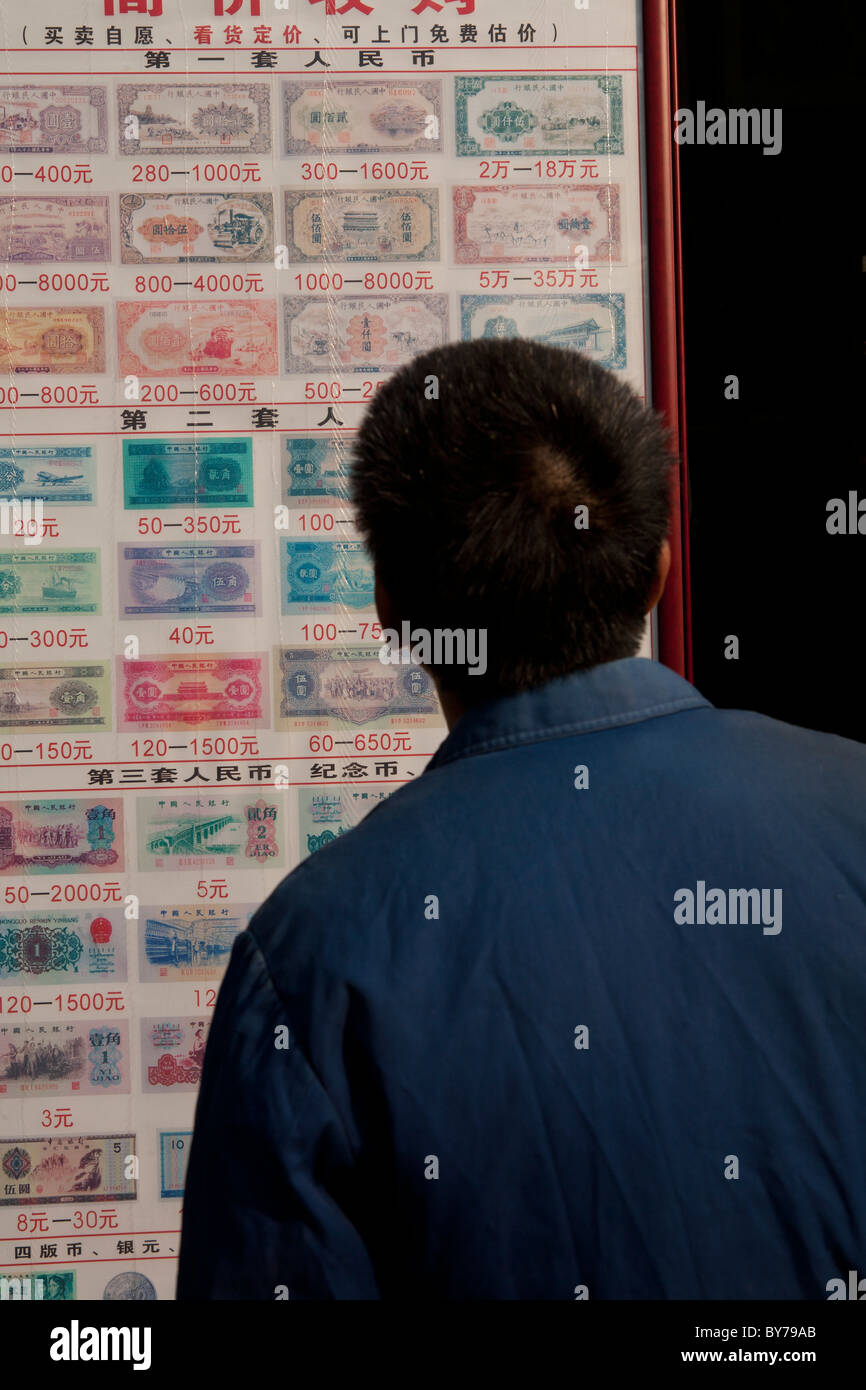 Mann, Blick auf Tabelle von Banknoten, Duolan Road, Shanghai, China Stockfoto