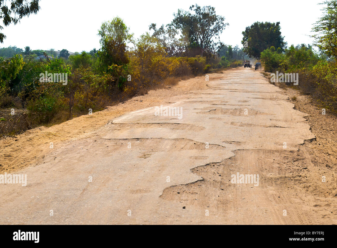Die verfallenen Teerstraße führt aus der Stadt von Morondava an der südwestlichen Küste von Madagaskar. Stockfoto
