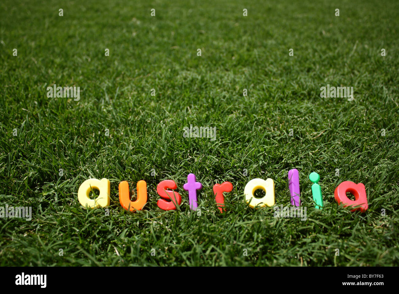 Das Wort "Australia" ausgeschrieben in bunten Buchstaben aus Kunststoff, auf dem grünen Rasen, genommen aus einem niedrigen Winkel Stockfoto