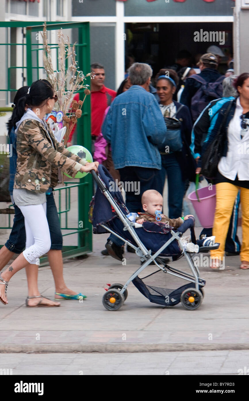 Kuba, Havanna. Straßenszene. Mutter drängt Baby im Kinderwagen. Stockfoto