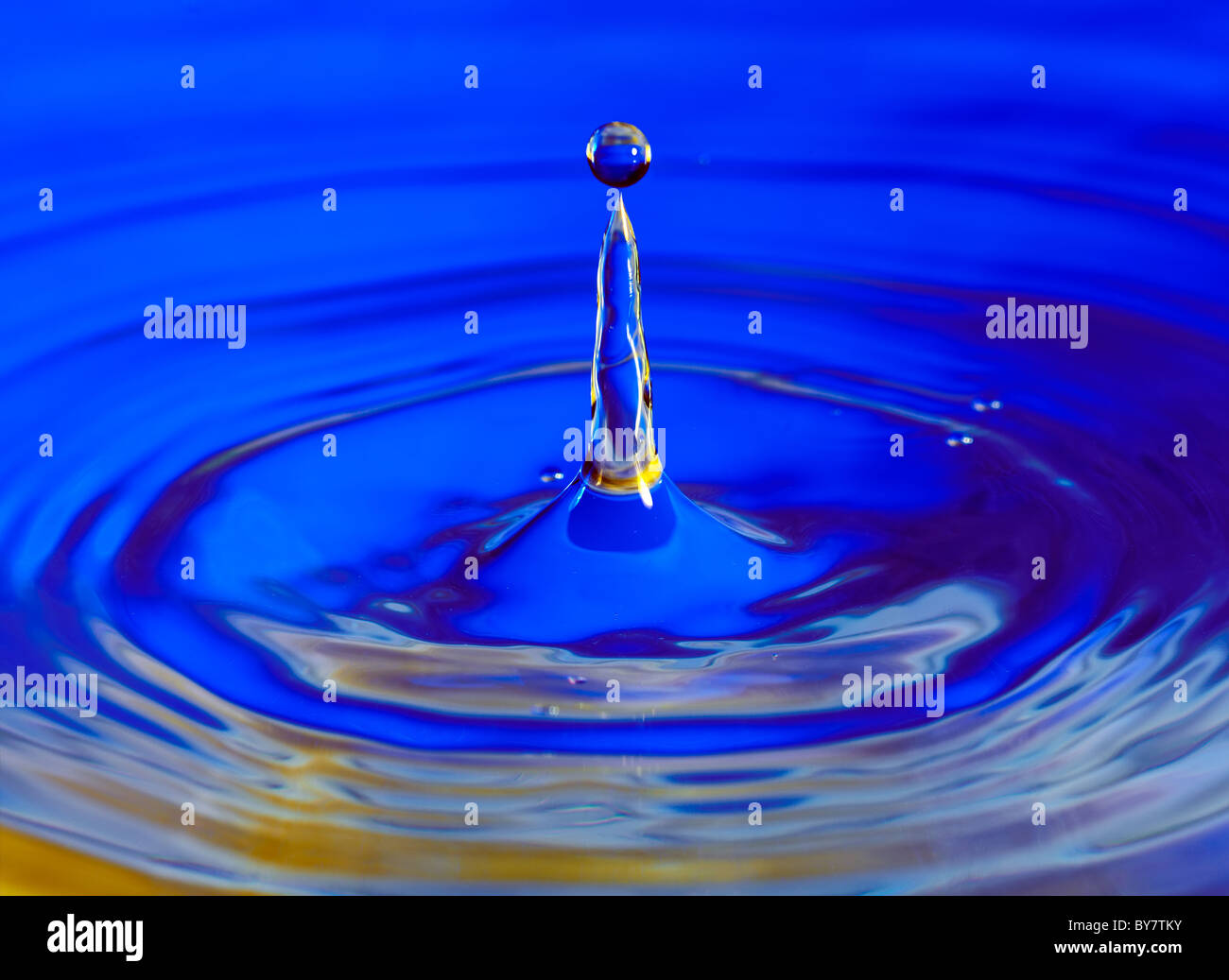 Wasser Tropfen Splash Makro in blau mit gold-highlights Stockfoto