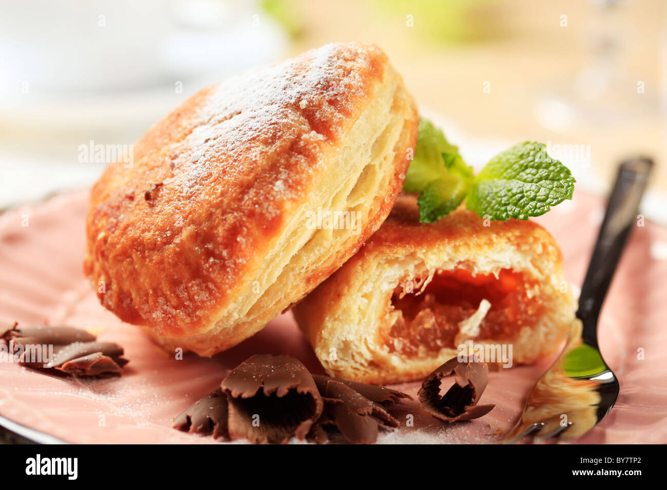 Marmelade gefüllte Krapfen auf einem rosa Teller Stockfoto