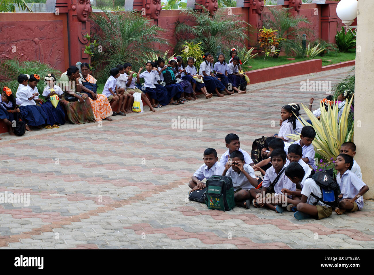indischer Dorfschule Kinder sitzen vor einem Wasserpark für Studienreise, Kanyakumari, Tamilnadu, Indien Stockfoto