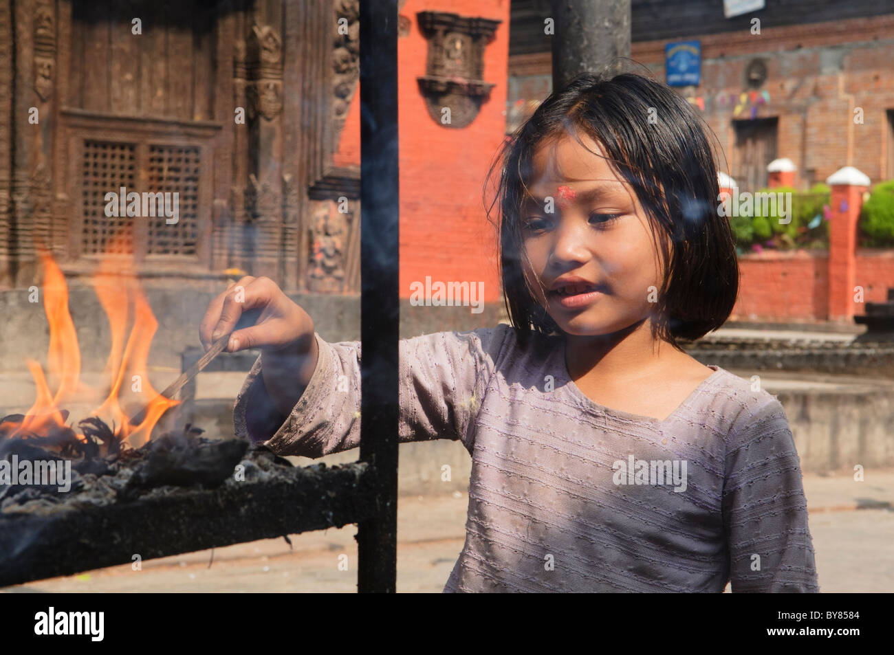 Mädchen macht ein Angebot in einem Schrein während Tihar-Festivals in Kathmandu, Nepal Stockfoto