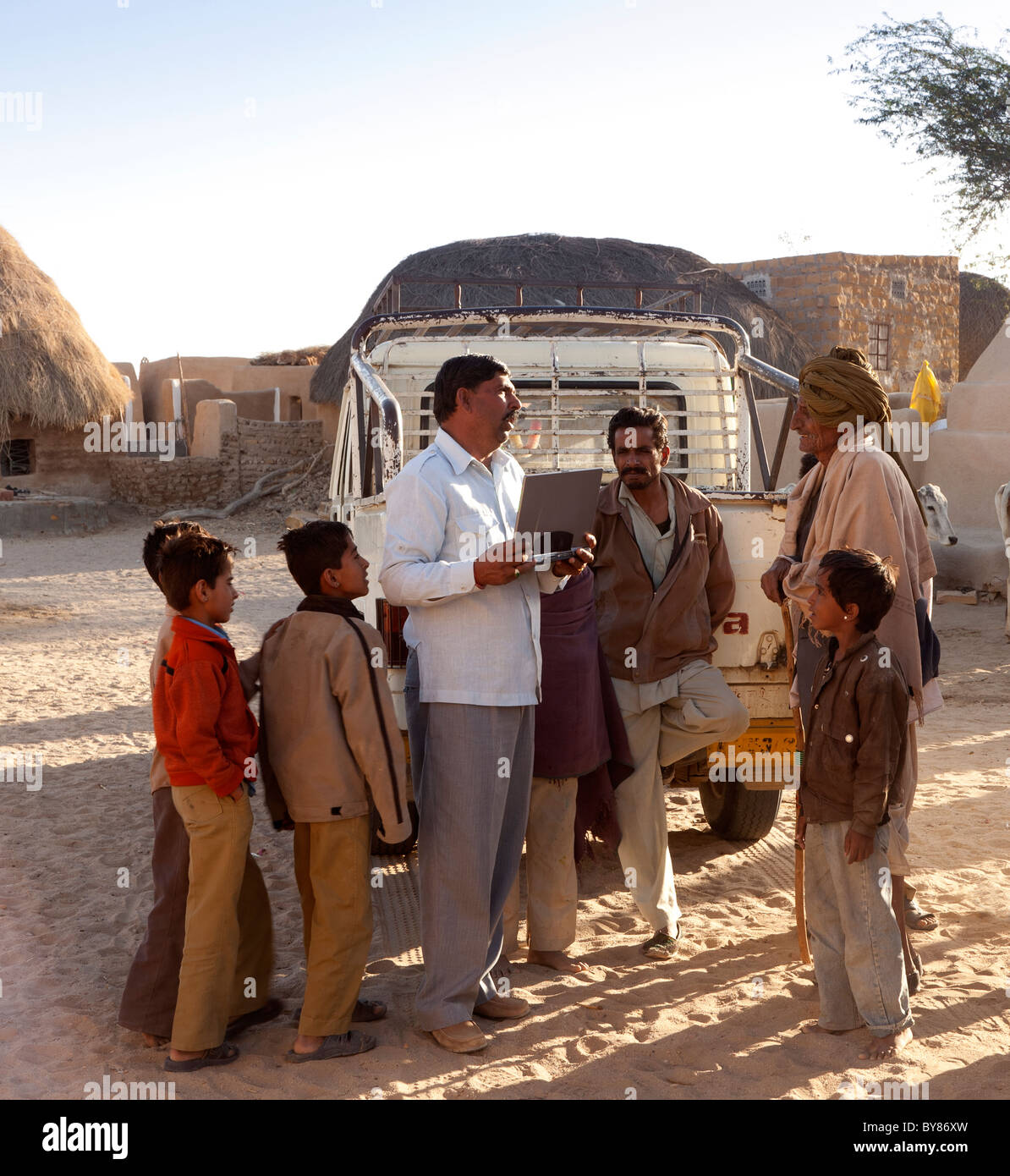 Indien, Rajasthan, Thar-Wüste, Bezirk Bürgermeister Dorfbewohner besuchen und halten laptop Stockfoto
