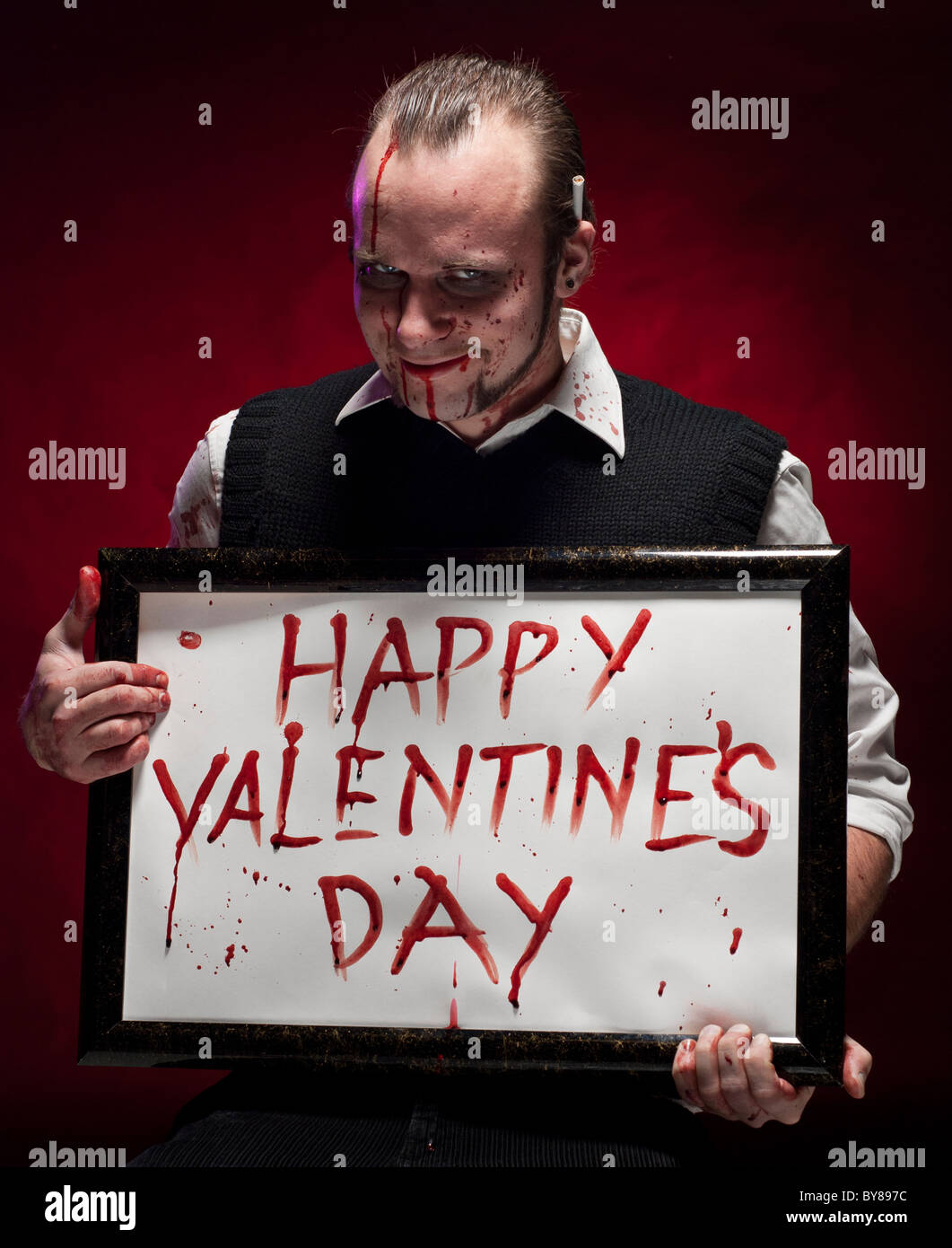 Mann hält ein happy Valentine Schild mit Blut geschrieben. Stockfoto