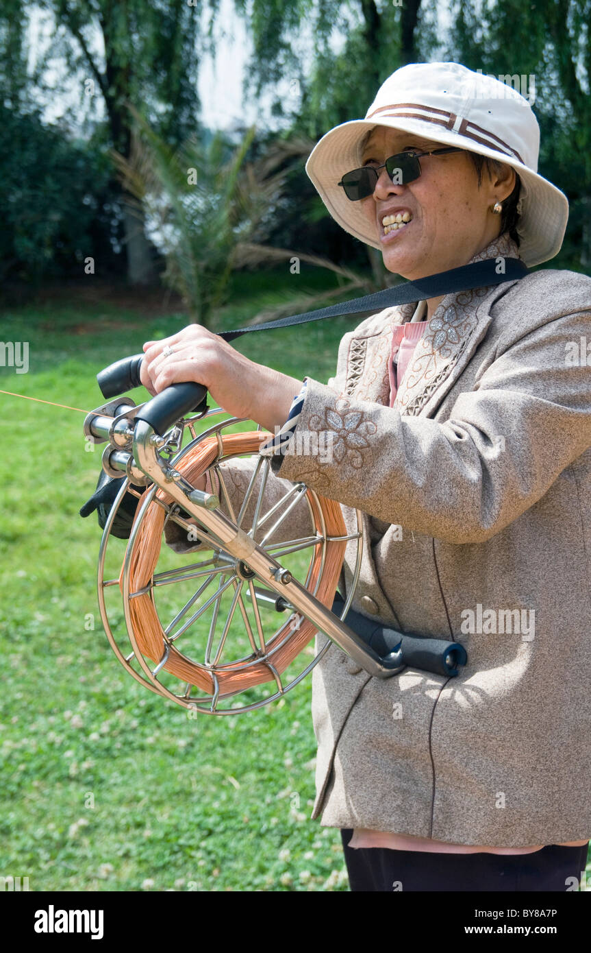 CHINA Senior ältere Frau fliegenden Drachen in einem Park in Kunming Yunnan Provinz Stockfoto