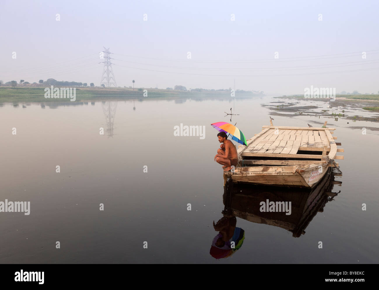 Indien, Agra, Uttar Pradesh Fischer am Boot mit bunten Regenschirm Stockfoto