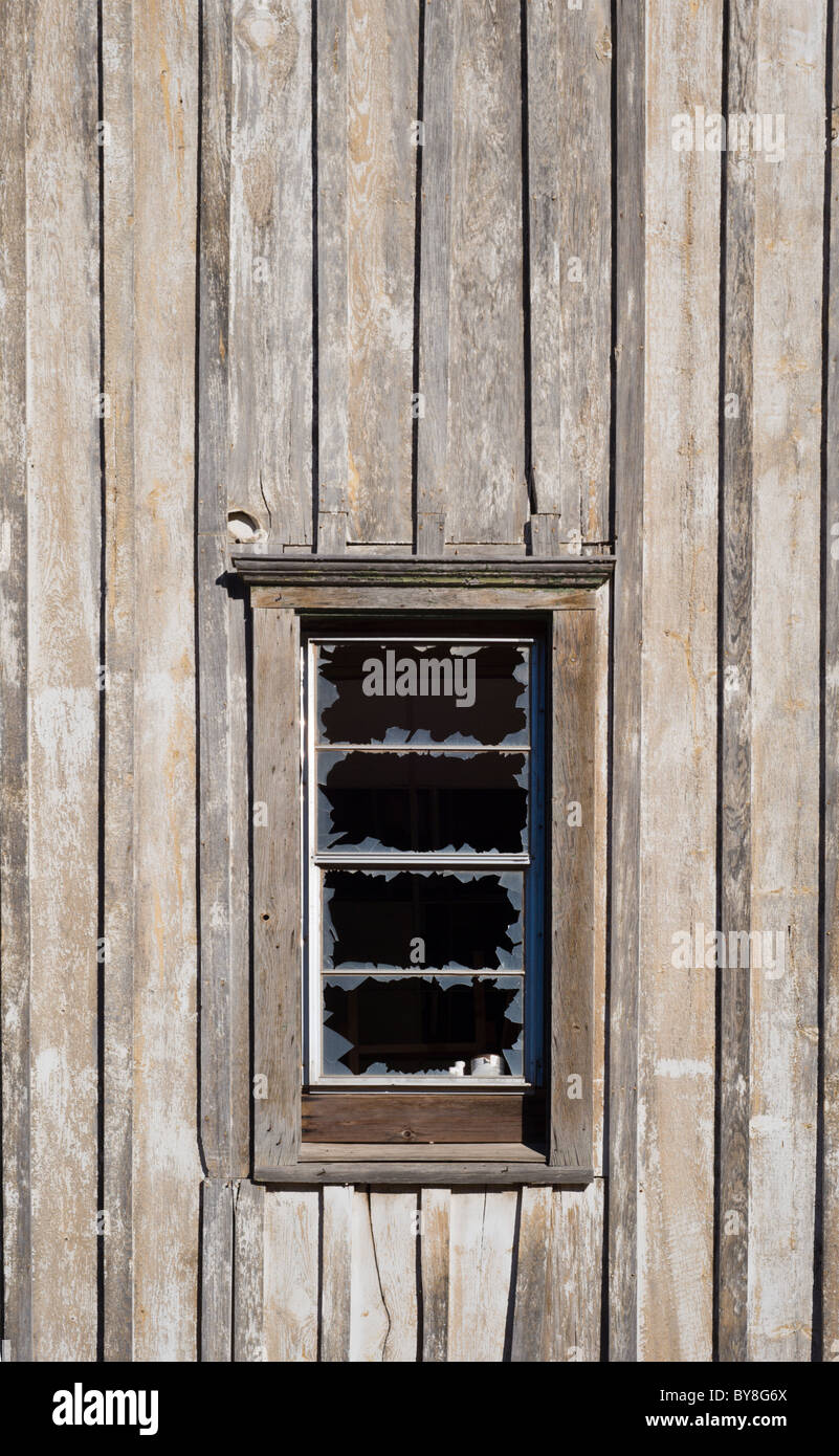 Ein altes Holzgebäude mit einem zerbrochenen Fenster im Mescalero-Indianer-Reservat, New Mexico. Stockfoto