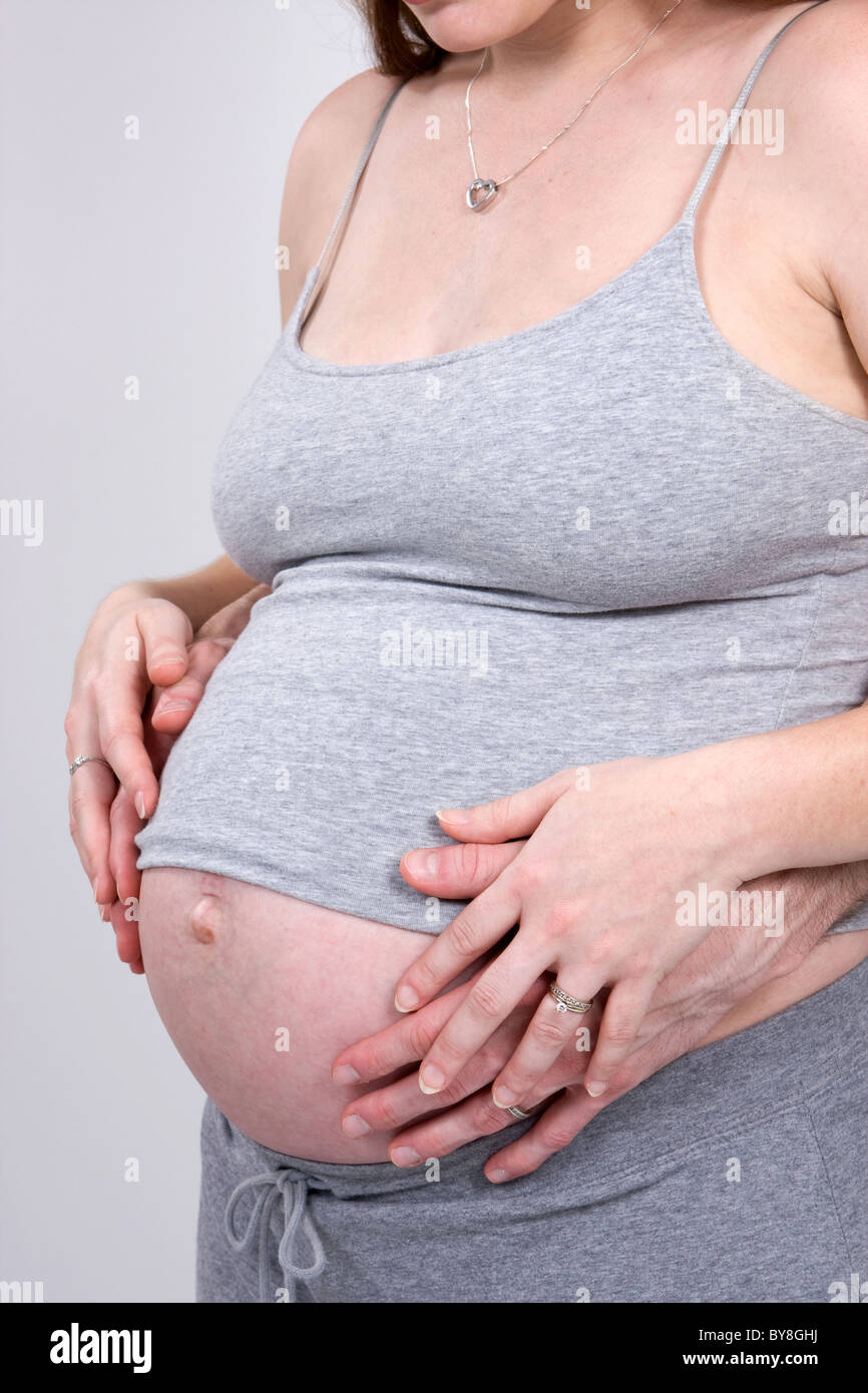 Eine schwangere paar legen ihre Hände auf die geschwollenen Bauch der Frau. Stockfoto