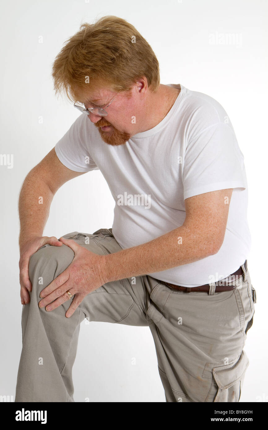Mann massiert eine alte Sportverletzung, die Schmerzen zu lindern. Stockfoto