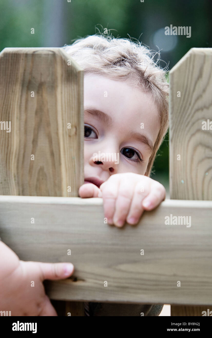 das Kind Loocking spielerischen Holztür Stockfoto