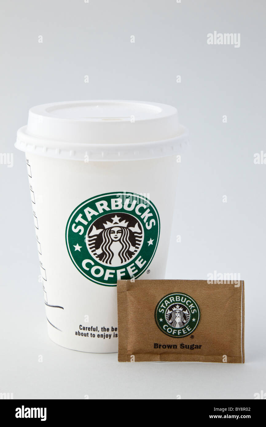 Starbucks Takeaway verfügbare Papier Kaffee Tasse takeout mit Kunststoff Getränk - durch Deckel und ein Päckchen von braunem Zucker. England Großbritannien Großbritannien Stockfoto