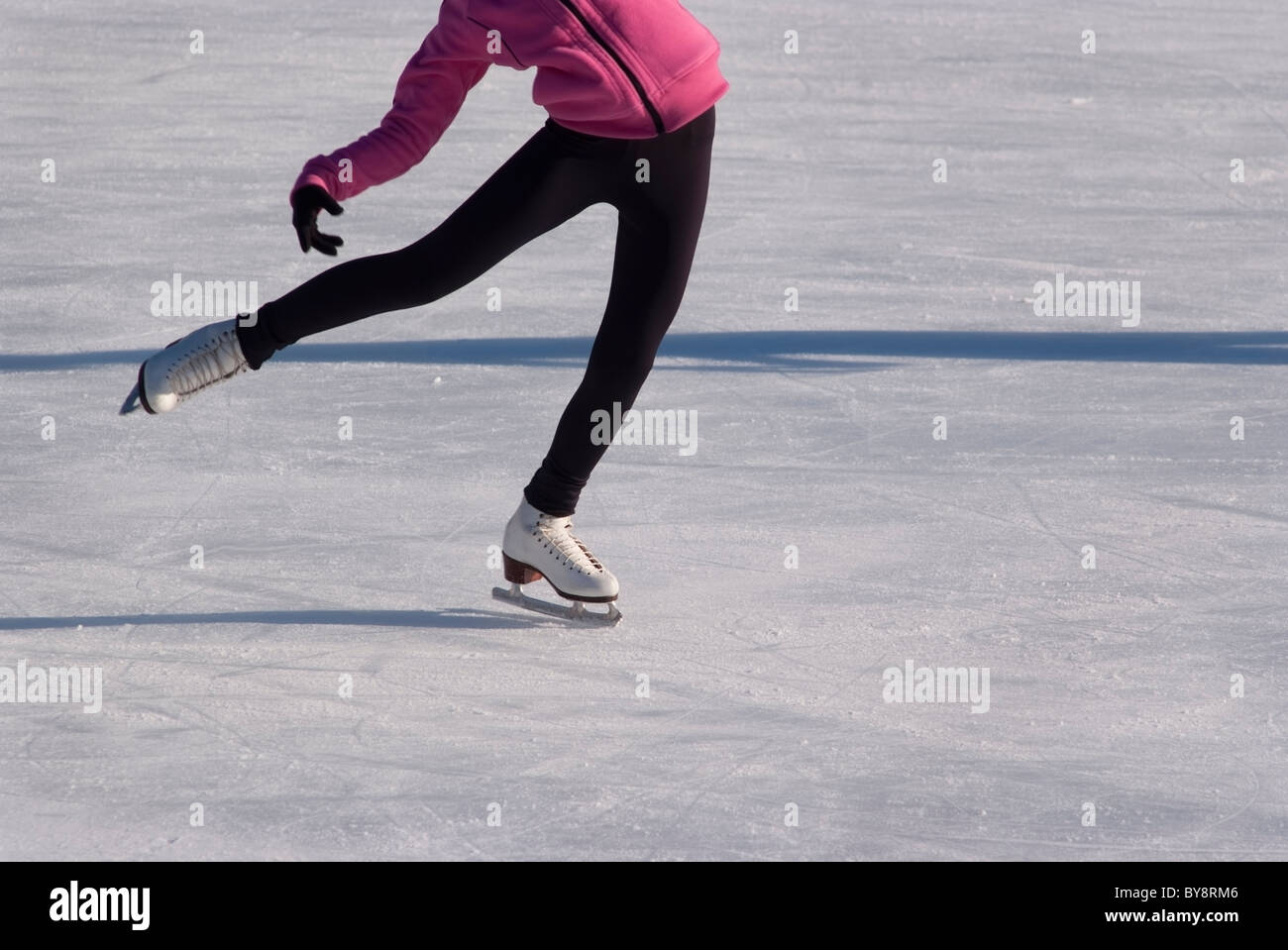 Weibliche Abbildung Skater üben eine seitliche Neigung Spritztour auf der North Park Ice Skating Rink in Allison Park in der Nähe von Pittsburgh, PA Stockfoto