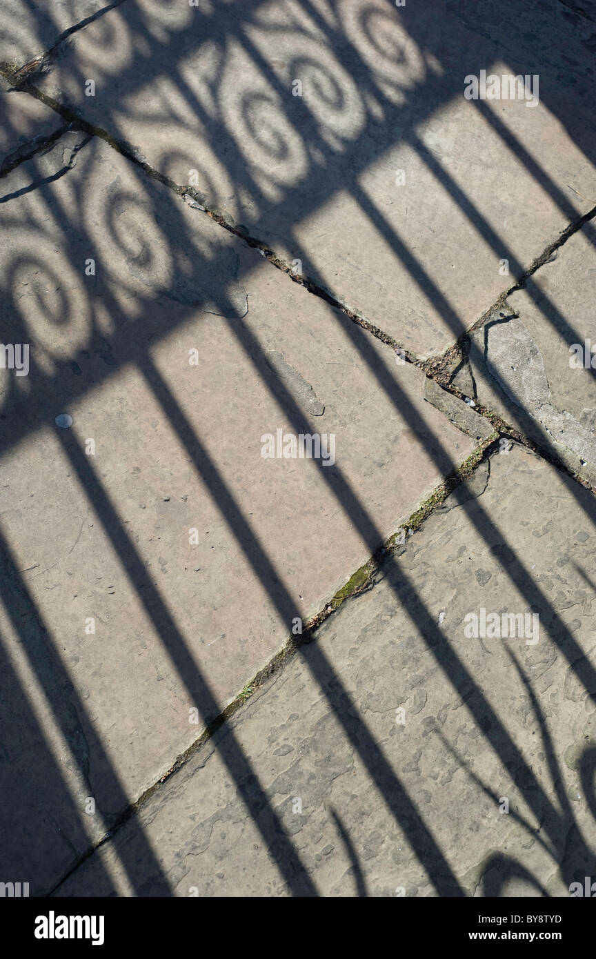 Schatten Besetzung vor Ort durch eine viktorianische dekorative Eisentor an einem sonnigen Herbsttag Stockfoto