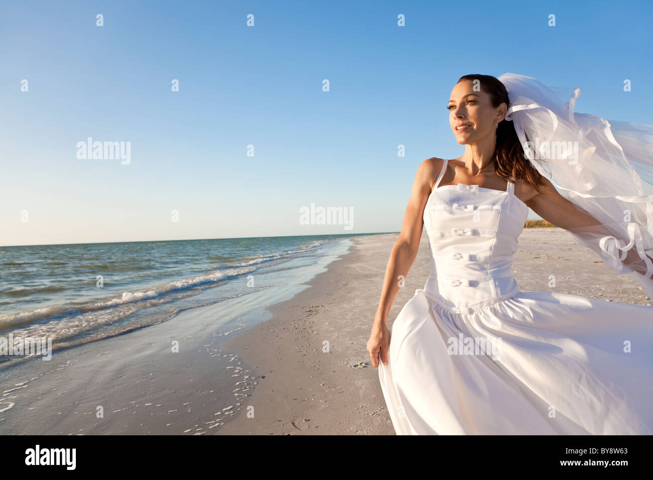 Eine verheiratete Frau Braut bei ihrer Hochzeit kleiden sich in goldene Abendsonne am tropischen Strand Stockfoto