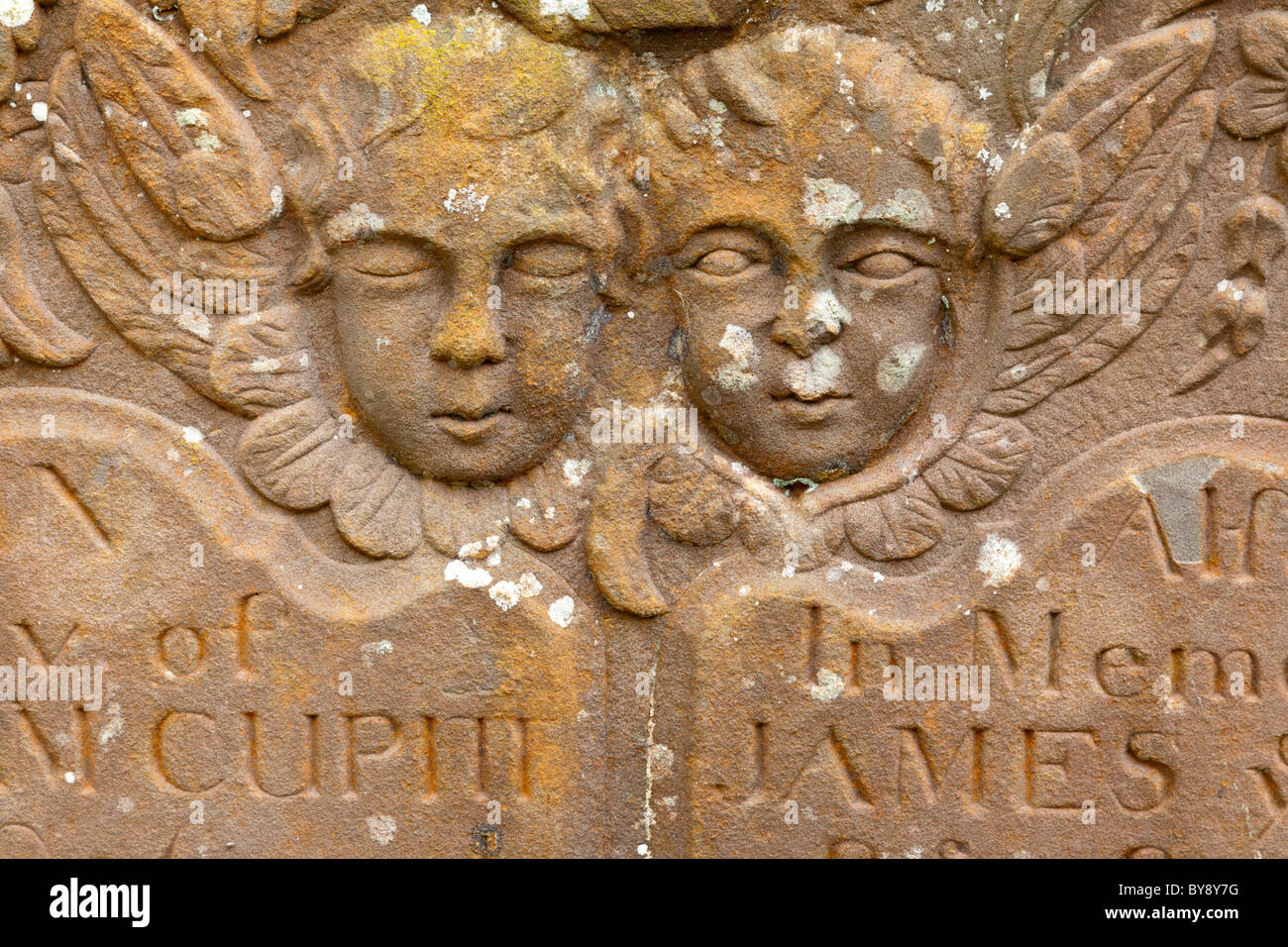 Zwei Putten (ein Augen zu öffnen, ein Augen geschlossen) auf einem Grabstein auf dem Friedhof in Awre, Gloucestershire Stockfoto