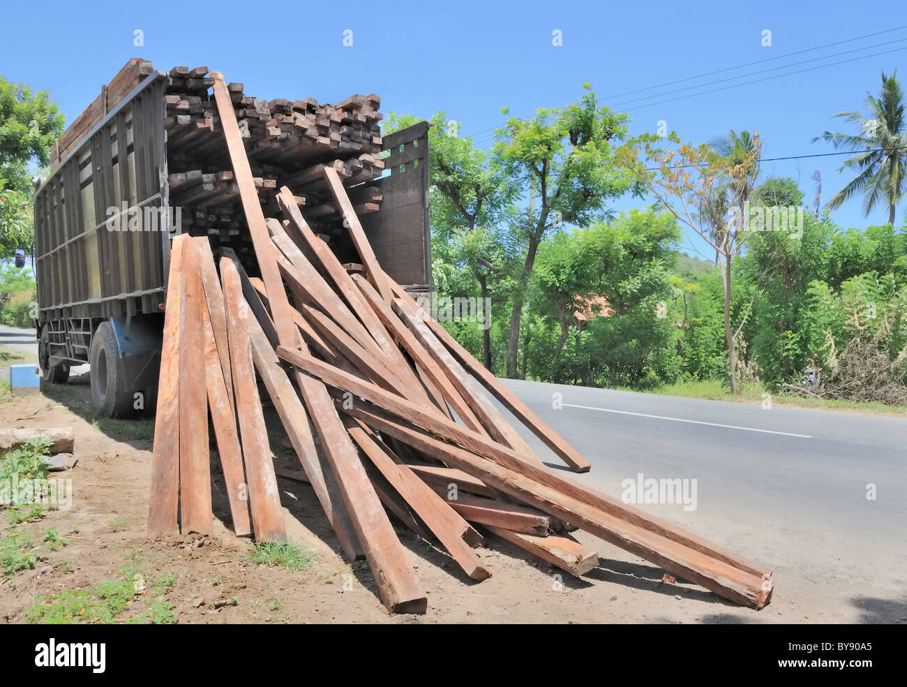 LKW-offloading tropisches Hartholz auf einer Baustelle in Bali, Indonesien Stockfoto