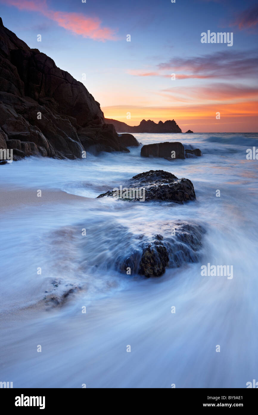 Gezeiten der Flut an Land drängen und waschen über Felsen am Strand von Porthcurno, Cornwall Stockfoto