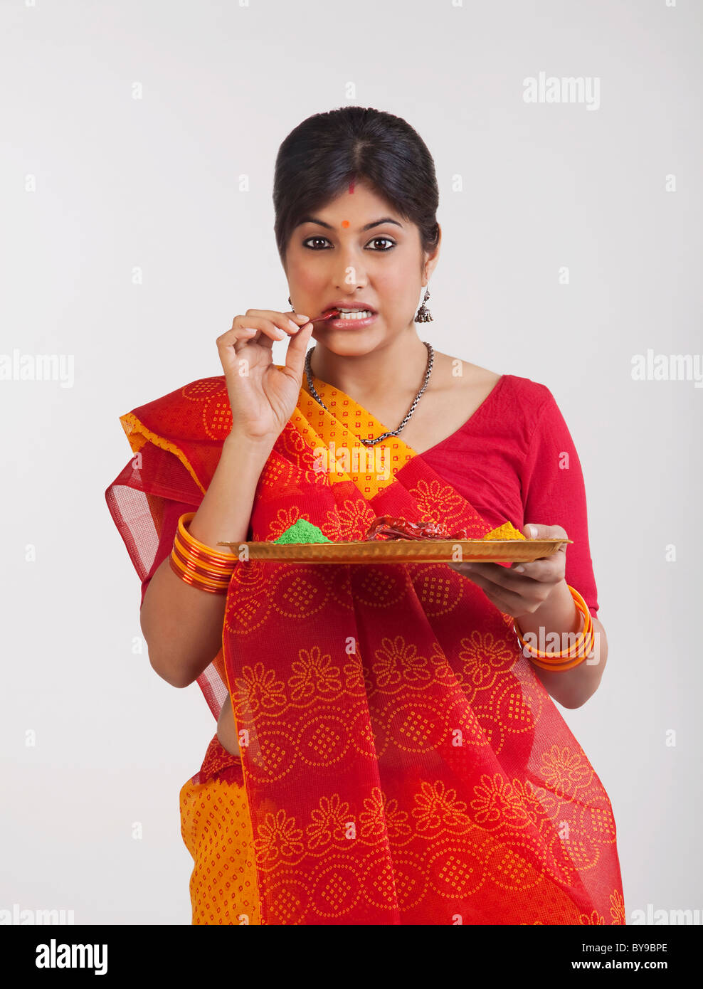 Rajasthani Frau essen eine rote Chilischote Stockfoto